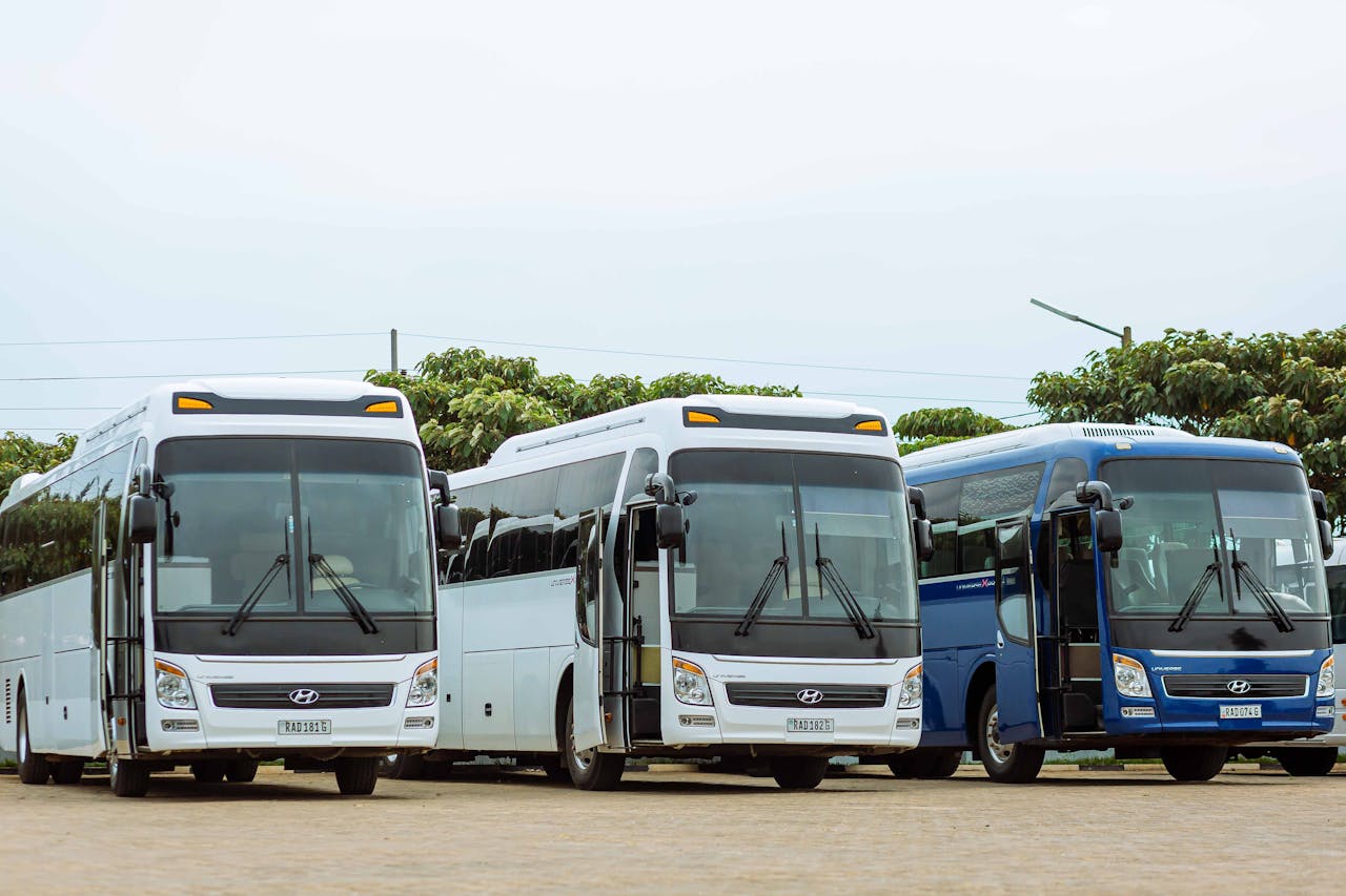 Mastering the First Impression: Your intriguing post title goes here Three Hyundai buses parked in an outdoor parking lot on a clear day.
